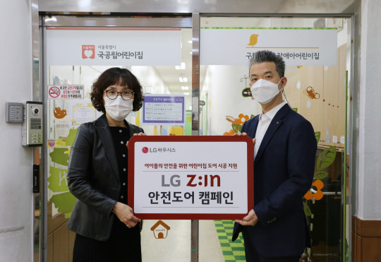 지난 23일 서울시 구로구에 위치한 아나율 장애아 어린이집에서 김경애(왼쪽) 원장과 유석희 LG하우시스 브랜드마케팅팀 팀장이 도어 교체를 완료하고 기념 촬영을 하고 있는 모습. LG하우시스 제공